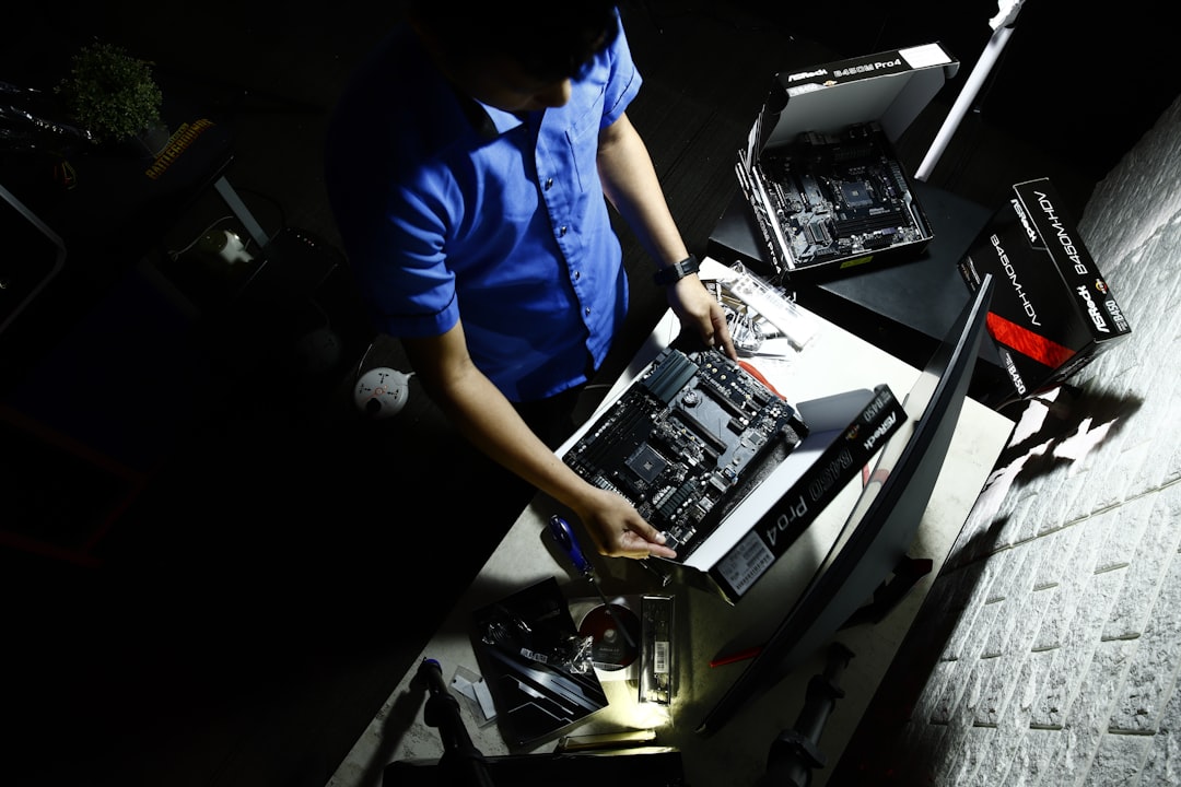 a-man-in-a-blue-shirt-working-on-a-computer-52u9wpda5qw